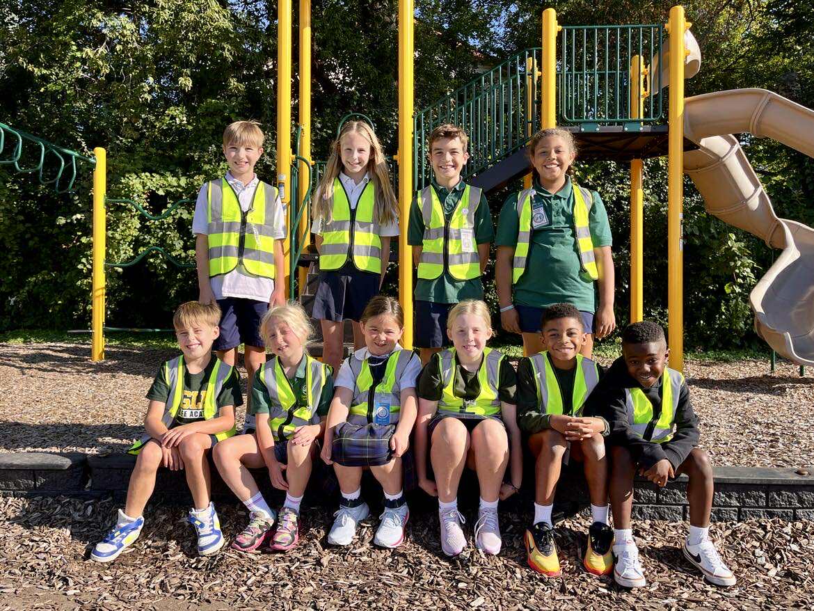 Group of middle school boys at New Life Academy work together on a science project using wood sticks and plastic to build a prototype