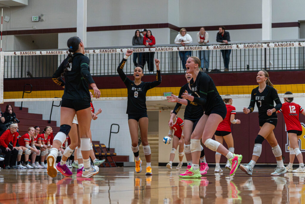 New Life Academy Girls Varsity Volleyball Team celebrates together during game play